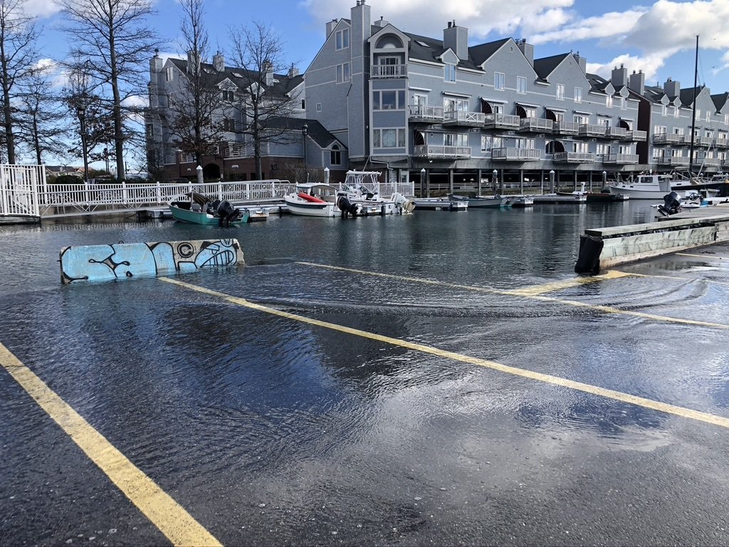 Rising waters are flooding the streets in front of a condominium.