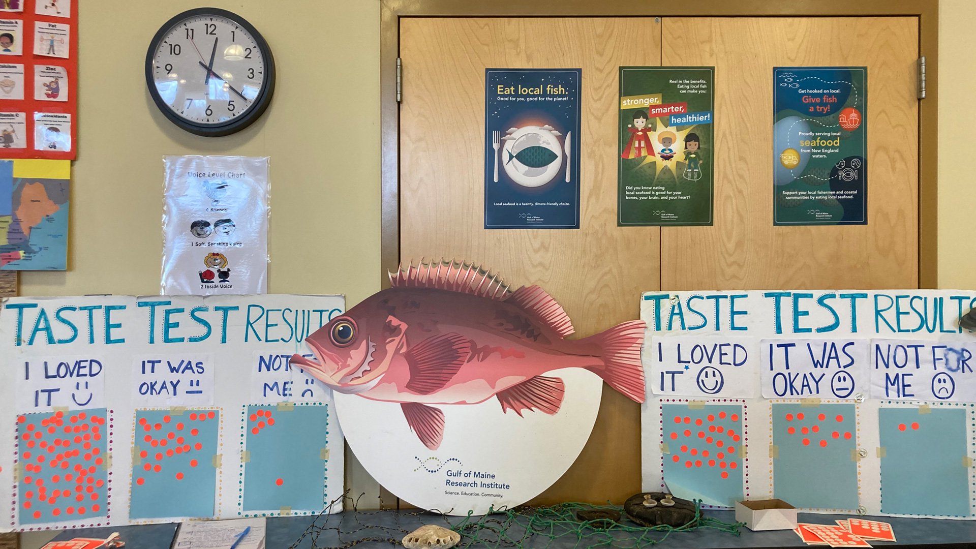 Several seafood-centric signs sit on tables, including taste test result sings where orange stickers sit under the phrases "I love it", "It was okay", and "Not for me". A big redfish poster sits center frame.