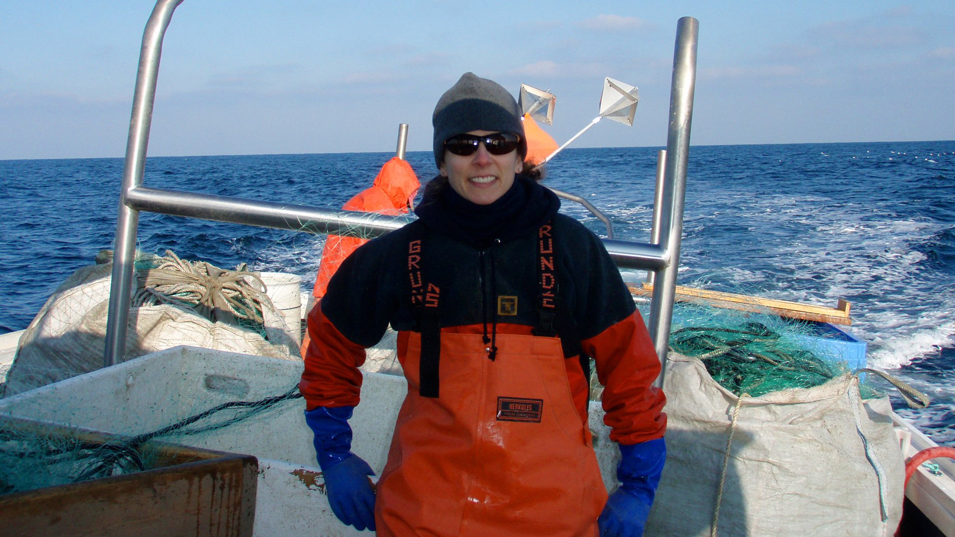 Dr. Lisa Kerr poses for the camera while standing on a boat in sunglasses.