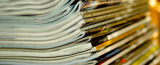 A close up shot of a stack of magazines and journals