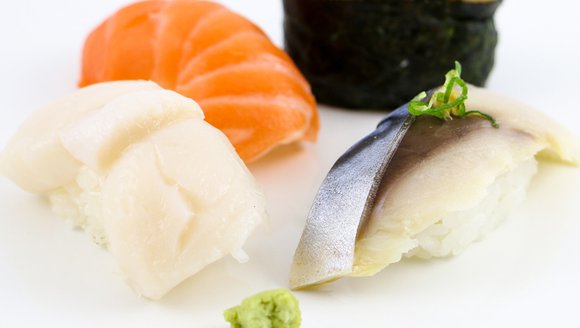This image shows sushi up close sitting on a white table.