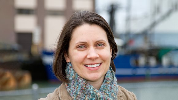 A portrait of Research Scientist Kathy Mills against a waterfront backdrop